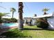 Secluded backyard features a covered patio, pool and ample lawn space perfect for relaxing and entertaining at 519 E El Camino Dr, Phoenix, AZ 85020