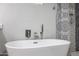 Freestanding white tub with modern fixtures and decorative tile surround at 519 E El Camino Dr, Phoenix, AZ 85020
