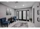 Bright living room featuring stylish furniture, modern decor, and double doors leading to the outdoors at 519 E El Camino Dr, Phoenix, AZ 85020