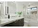 Contemporary bathroom featuring a lighted mirror, marble countertops, and a bathtub with a glass enclosure at 5318 N 24Th Pl, Phoenix, AZ 85016