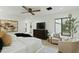 Bright bedroom featuring a ceiling fan, hardwood floors, and a view of the outdoor greenery at 5318 N 24Th Pl, Phoenix, AZ 85016