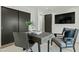 A modern office space with a gray desk, a comfortable chair, a sliding door closet, and a wall-mounted TV at 5318 N 24Th Pl, Phoenix, AZ 85016