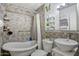 Cozy bathroom with tub and shower, brick tile walls, vessel sink, and decorative details at 5407 W Cambridge Ave, Phoenix, AZ 85035