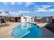 Sparkling pool surrounded by backyard furniture and a white house at 5407 W Cambridge Ave, Phoenix, AZ 85035