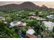 Scenic aerial perspective of the property, featuring a sparkling pool, patio area, and verdant landscaping with mountain views at 6019 N 62Nd Pl, Paradise Valley, AZ 85253