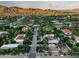 Expansive aerial view of a neighborhood with lush greenery, large homes, and mountain views in the background at 6019 N 62Nd Pl, Paradise Valley, AZ 85253