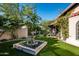 Beautiful backyard with artificial turf, a fountain, and lush landscaping with mature trees and flowering vines at 6019 N 62Nd Pl, Paradise Valley, AZ 85253