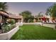 Beautiful backyard with vibrant landscaping, a lush lawn, and comfortable lounge areas perfect for entertaining at 6019 N 62Nd Pl, Paradise Valley, AZ 85253