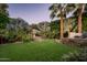 Well-maintained backyard with lush green grass, elegant fountain, and beautiful landscaping at 6019 N 62Nd Pl, Paradise Valley, AZ 85253