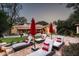 Relaxing backyard patio with lounge chairs, red umbrellas, and views of the surrounding landscape at 6019 N 62Nd Pl, Paradise Valley, AZ 85253