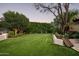 Beautiful backyard with lush green lawn surrounded by mature trees and manicured landscaping at 6019 N 62Nd Pl, Paradise Valley, AZ 85253