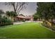 Lush backyard with well-manicured lawn, mature landscaping, and an inviting patio area at 6019 N 62Nd Pl, Paradise Valley, AZ 85253