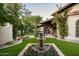 Beautiful backyard with a fountain, lush lawn, desert landscaping, and a covered patio at 6019 N 62Nd Pl, Paradise Valley, AZ 85253