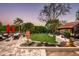 This landscaped backyard boasts a lush green lawn, patio and comfortable seating at 6019 N 62Nd Pl, Paradise Valley, AZ 85253