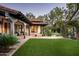 Serene backyard with well-maintained lawn, stone patio, a fountain, and an inviting covered porch at 6019 N 62Nd Pl, Paradise Valley, AZ 85253