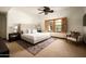 Bright bedroom with a cozy rug, king bed, ceiling fan, and shuttered windows overlooking the lush outdoors at 6019 N 62Nd Pl, Paradise Valley, AZ 85253