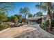 Elegant home with a brick driveway, outdoor lounge chairs, and manicured landscaping at 6019 N 62Nd Pl, Paradise Valley, AZ 85253