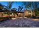 Charming home with brick driveway, featuring an outdoor kitchen, seating area, and lush greenery at 6019 N 62Nd Pl, Paradise Valley, AZ 85253