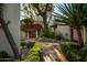 Picturesque garden pathway with manicured hedges leading to a wooden gate adorned with vibrant bougainvillea at 6019 N 62Nd Pl, Paradise Valley, AZ 85253