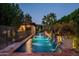 Inviting pool with fountains, lush landscaping, and a covered patio, creating a private outdoor oasis at 6019 N 62Nd Pl, Paradise Valley, AZ 85253