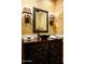 Stylish powder room with decorative mirror, wall sconces, and vessel sink at 6019 N 62Nd Pl, Paradise Valley, AZ 85253