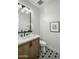 Stylish bathroom showcases a marble countertop, wooden vanity, and black-and-white patterned tile floor at 6500 E Camelback Rd # 1010, Scottsdale, AZ 85251