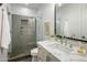 Modern bathroom features a glass-enclosed shower with a gray tiled wall, marble countertop, and white cabinetry at 6500 E Camelback Rd # 1010, Scottsdale, AZ 85251