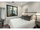 Bright bedroom featuring a luxurious bed with a plush white comforter and large window viewing stone courtyard at 6500 E Camelback Rd # 1010, Scottsdale, AZ 85251