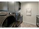 Well-equipped laundry room with modern washer and dryer, custom cabinets, and ample counter space at 6500 E Camelback Rd # 1010, Scottsdale, AZ 85251