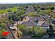Aerial view of the desert home and golf course community, featuring a pool, patio, and desert landscaping at 6591 E Amber Sun Dr, Scottsdale, AZ 85266