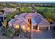 Aerial view of house with manicured desert landscaping, 3-car garage, and tile roof at 6591 E Amber Sun Dr, Scottsdale, AZ 85266