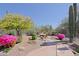 Lush backyard with vibrant desert plants, stone patio, and cozy fire pit area, perfect for outdoor living at 6591 E Amber Sun Dr, Scottsdale, AZ 85266