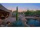 Expansive backyard features outdoor seating, BBQ, fireplace, pool, and mature desert landscaping at 6591 E Amber Sun Dr, Scottsdale, AZ 85266