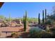 Relaxing backyard boasts a pool with waterfall, patio with seating, outdoor kitchen, and desert landscaping at 6591 E Amber Sun Dr, Scottsdale, AZ 85266