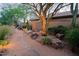 Home's desert landscaping has a stepping stone pathway surrounded by boulders and foliage at 6591 E Amber Sun Dr, Scottsdale, AZ 85266
