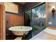 Bright bathroom featuring soaking tub and serene outdoor views of a rock garden at 6591 E Amber Sun Dr, Scottsdale, AZ 85266