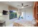 Bedroom with ceiling fan, window showcasing desert landscaping, and television mounted on the wall at 6591 E Amber Sun Dr, Scottsdale, AZ 85266
