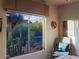 Bedroom window shows desert landscaping, a chair, and hat on the wall at 6591 E Amber Sun Dr, Scottsdale, AZ 85266