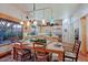 Dining room with a view to the kitchen, stylish lighting, dining table set for a meal, and desert landscape views at 6591 E Amber Sun Dr, Scottsdale, AZ 85266