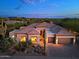 Desert home with a Spanish tile roof, three car garage, and desert landscaping at 6591 E Amber Sun Dr, Scottsdale, AZ 85266