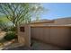 Tan home exterior with desert landscaping, including a mesquite tree and various cacti, and a side entrance at 6591 E Amber Sun Dr, Scottsdale, AZ 85266