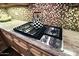 Bright kitchen features custom cabinets, granite counters, and gas cooktop at 6591 E Amber Sun Dr, Scottsdale, AZ 85266