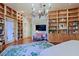 Expansive main bedroom features built-in shelves, wood floors, and an elegant chandelier at 6591 E Amber Sun Dr, Scottsdale, AZ 85266
