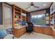 Office space features extensive built-in bookshelves, and a window showcasing desert landscape at 6591 E Amber Sun Dr, Scottsdale, AZ 85266