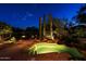 Backyard pool with rock features, enhanced with night lighting at 6591 E Amber Sun Dr, Scottsdale, AZ 85266