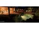 A tranquil pool is the centerpiece of the backyard oasis, illuminated at night at 6591 E Amber Sun Dr, Scottsdale, AZ 85266