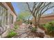 Serene side yard with desert landscaping, stone pathway, and mature trees, creating a tranquil outdoor retreat at 6591 E Amber Sun Dr, Scottsdale, AZ 85266