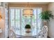 Cozy dining area with glass table, bright window views, and decorative light fixture at 7222 E Gainey Ranch Rd # 106, Scottsdale, AZ 85258