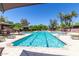 Stunning community pool featuring lounge chairs, palm trees, and plenty of space to relax on a sunny day at 7222 E Gainey Ranch Rd # 106, Scottsdale, AZ 85258
