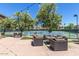 Community tennis courts with nearby lounge areas, chairs, tables and lovely shaded trees at 7222 E Gainey Ranch Rd # 106, Scottsdale, AZ 85258